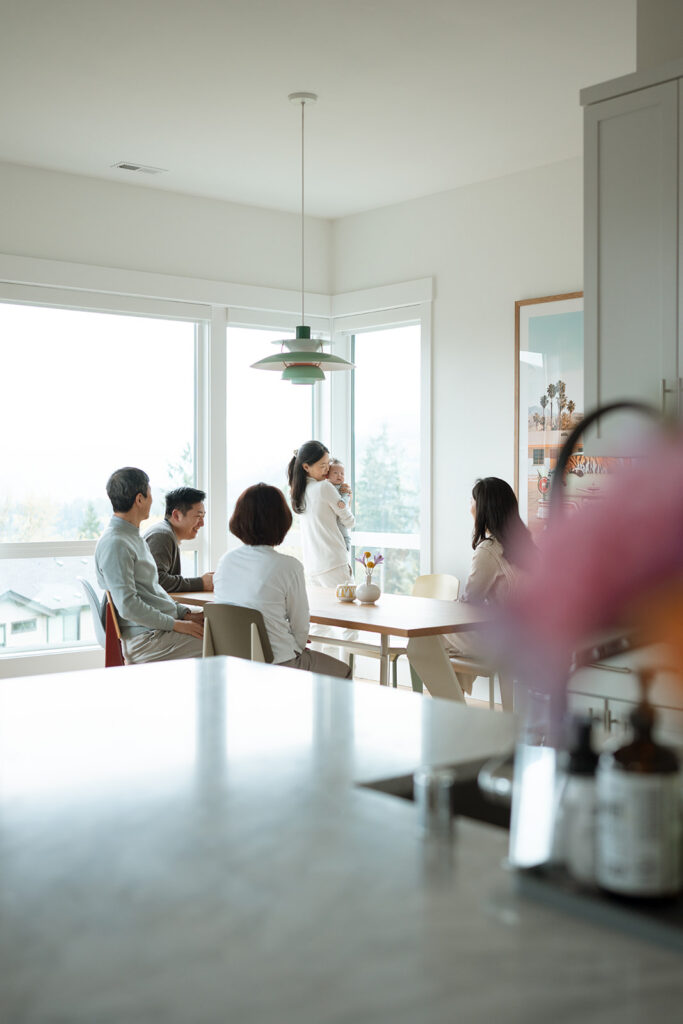 Family at dining table bathed in natural window light, at-home lifestyle session Orange County