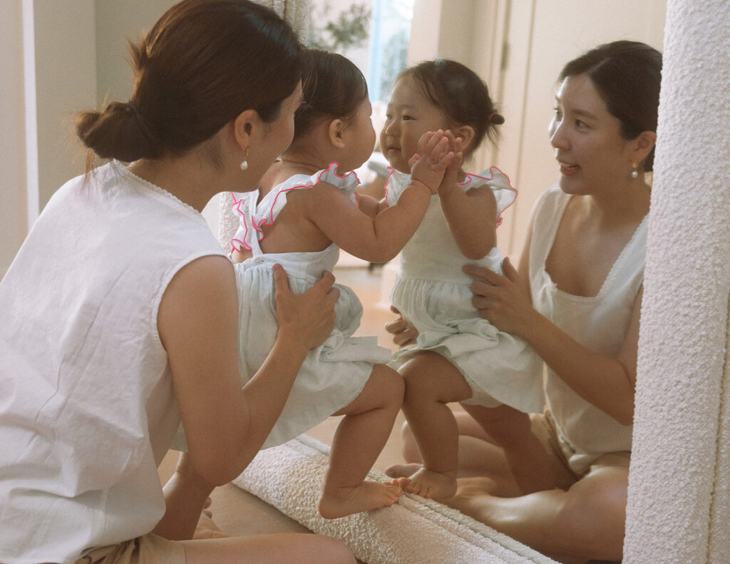 Irvine documentary family photographer captures mom and toddler laughing in mirror reflection
