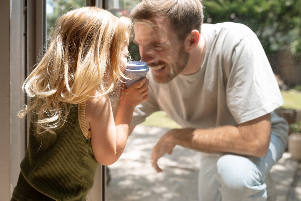 Commercial family lifestyle photography: father and daughter laughing together outdoors