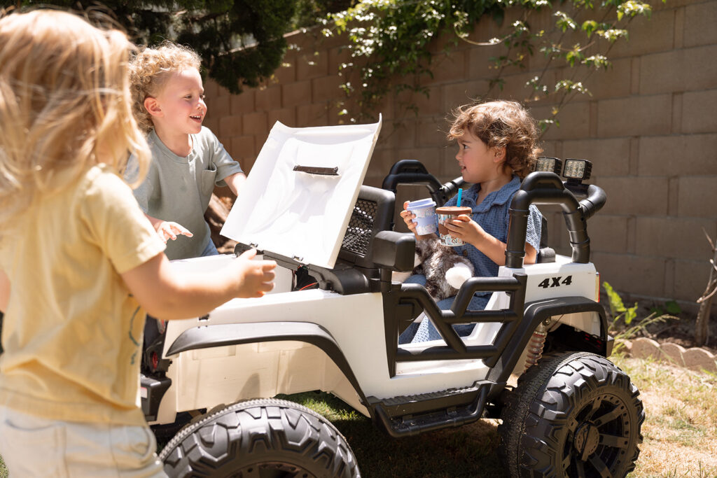 Children playing together with white toy vehicle in backyard-lifestyle brand photography